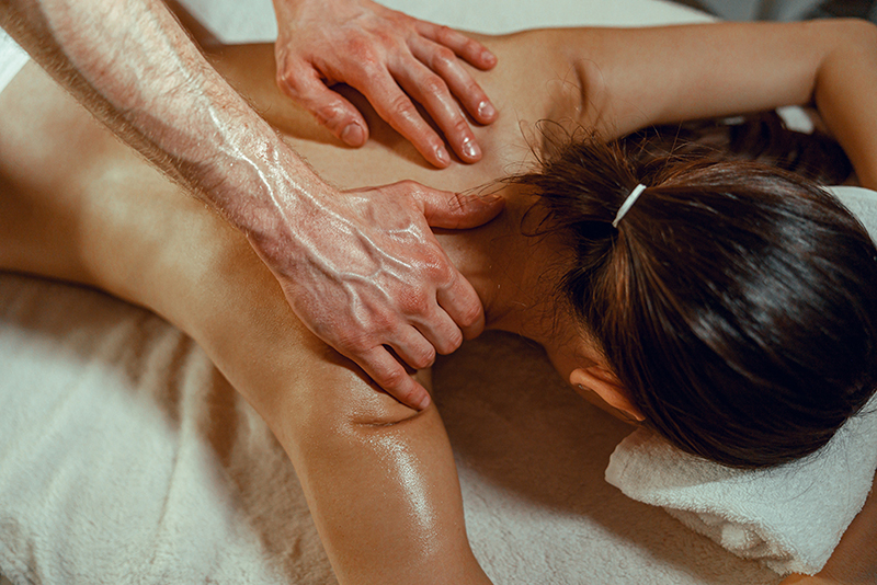 Woman receiving a relaxing full body massage with warm oils